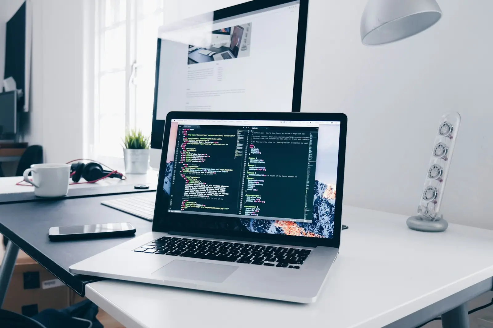 Laptop con código abierto sobre un escritorio luminoso